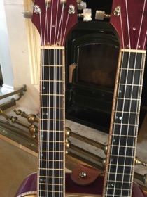 The fretboards wrapped and inlayed with abalone.
