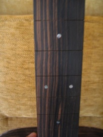 Prepare the fretboard to receive the frets and insert the abalone markers.